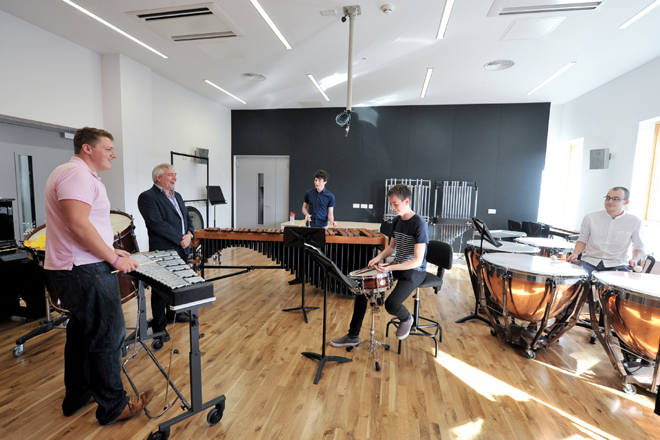David Hocking standing with percussion students playing instruments in the RCM's percussion suite.